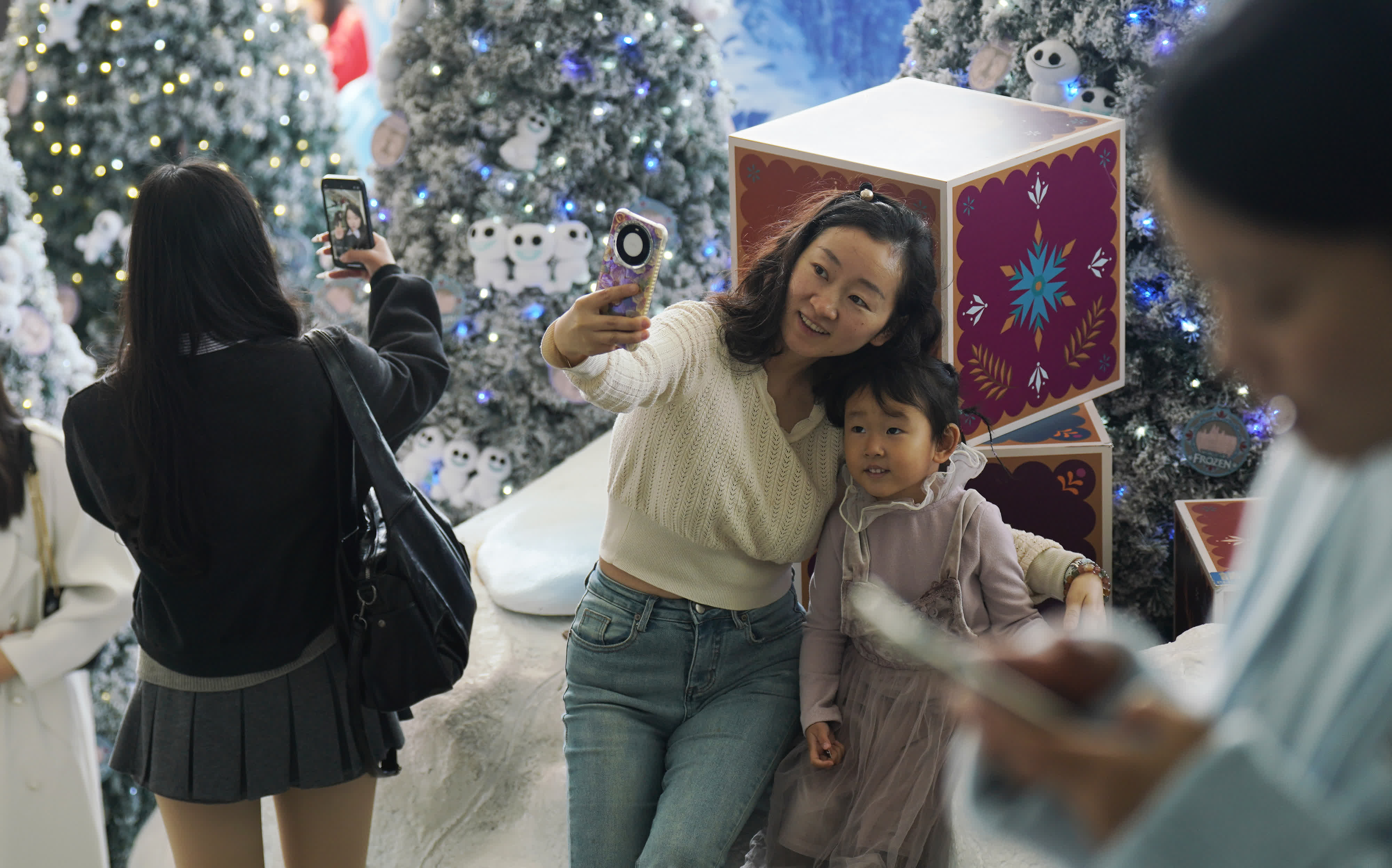 圖為遊客與市(shi)民(mín)在(zai)海港城(cheng)聖誕裝飾前(qian)拍照打卡。（香港中(zhong)通(tong)社(she))）
